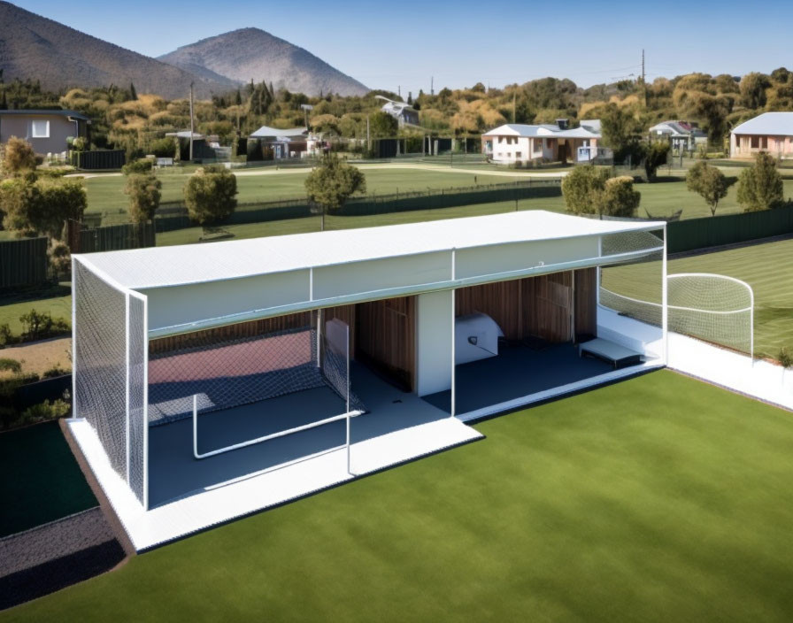 Covered Sports Area with Bench, Netting, Grass Field, Trees, and Houses under Clear Sky