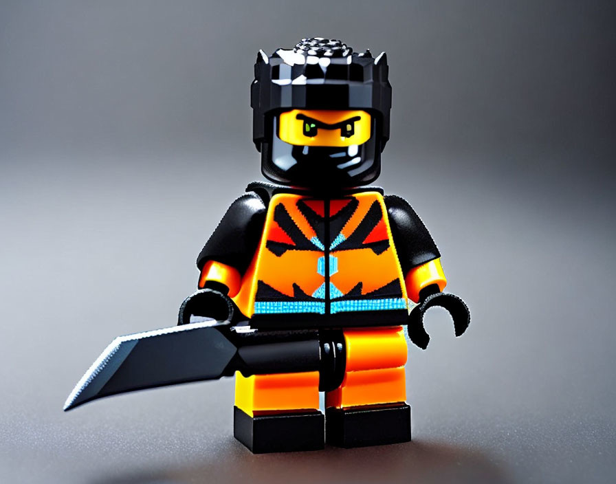 Lego ninja figurine with black helmet and sword on grey background