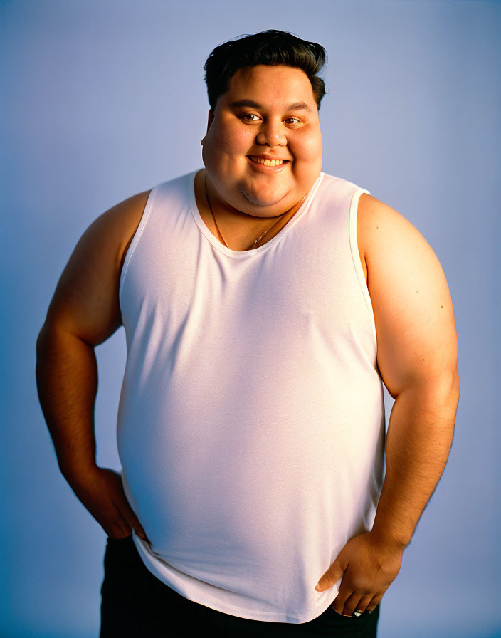 Smiling person in white tank top on blue background