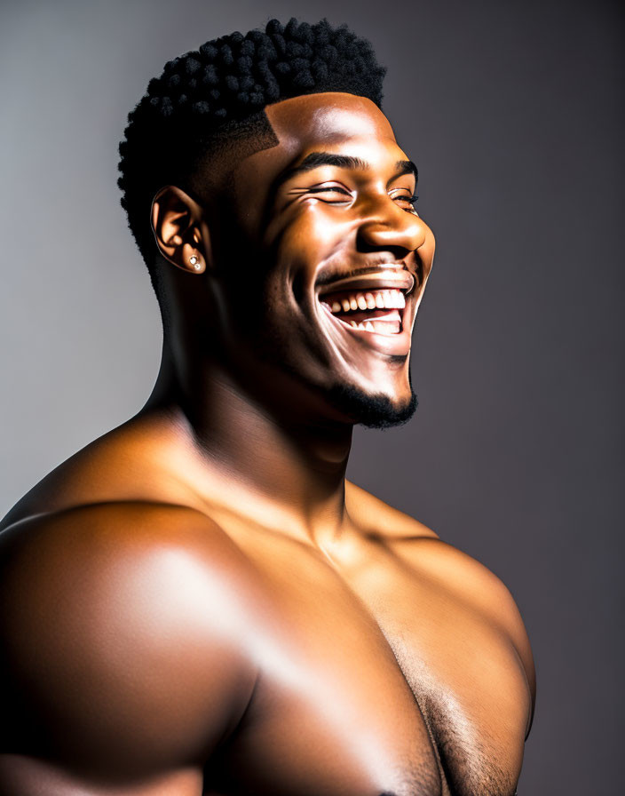 Smiling shirtless man with earring on gray background