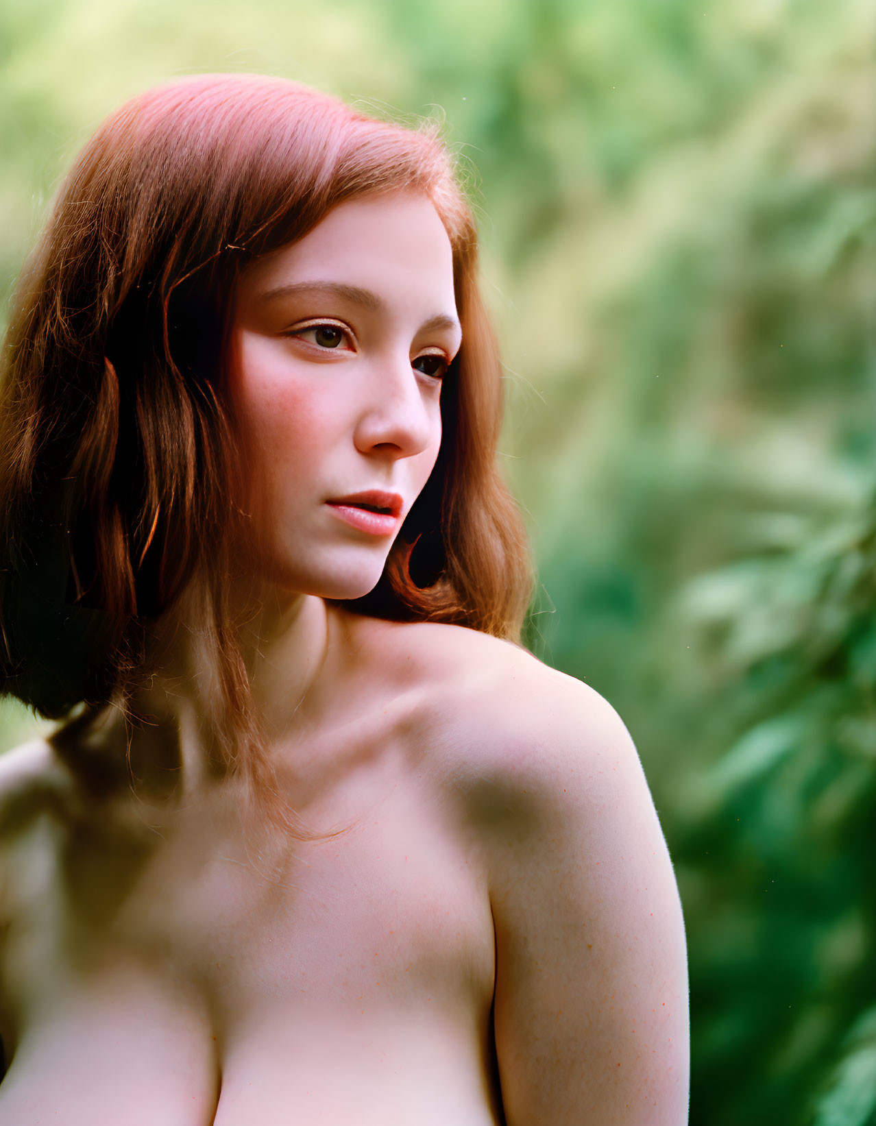 Portrait of young woman with red hair on blurred green background