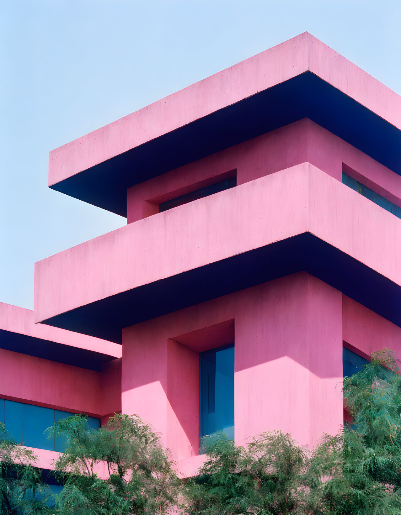 Bold Geometric Architecture of Vibrant Pink Building Against Blue Sky