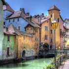 Colorful houses by canal with reflections and boat tied to dock