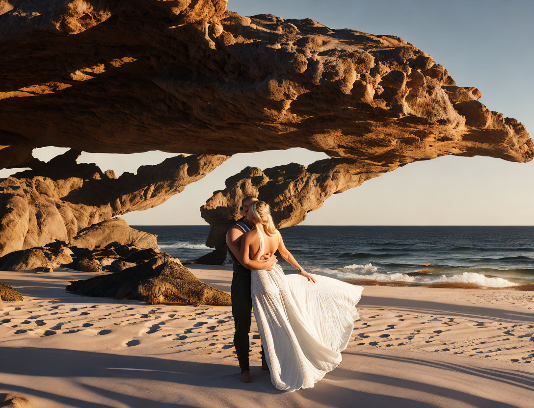 Woman in flowy dress on sandy beach at golden hour