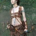 Digital Artwork: Female Warrior with Blue Face Markings and Bow in Forest