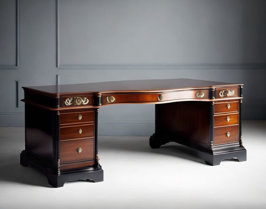 Wooden corner desk with brass handles on drawers against grey background