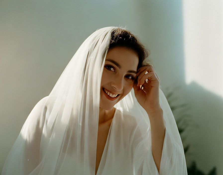 Smiling woman with white veil in soft light