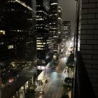 Urban night scene with glowing skyscrapers, empty street, and dramatic sky