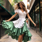 Woman in white and green ruffled dress walking in alleyway