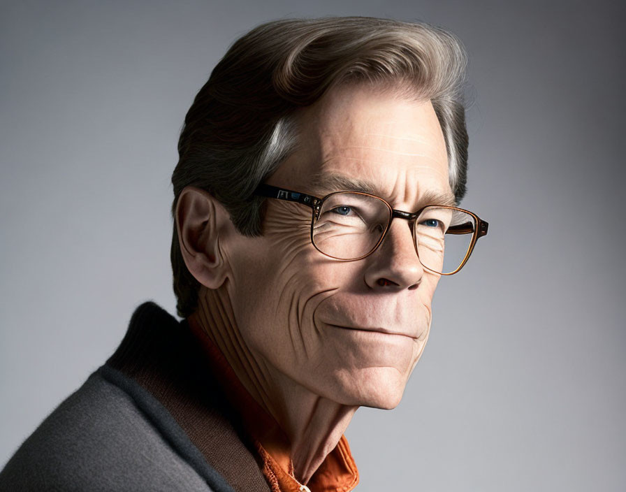 Smiling man with grey hair in glasses and orange sweater portrait