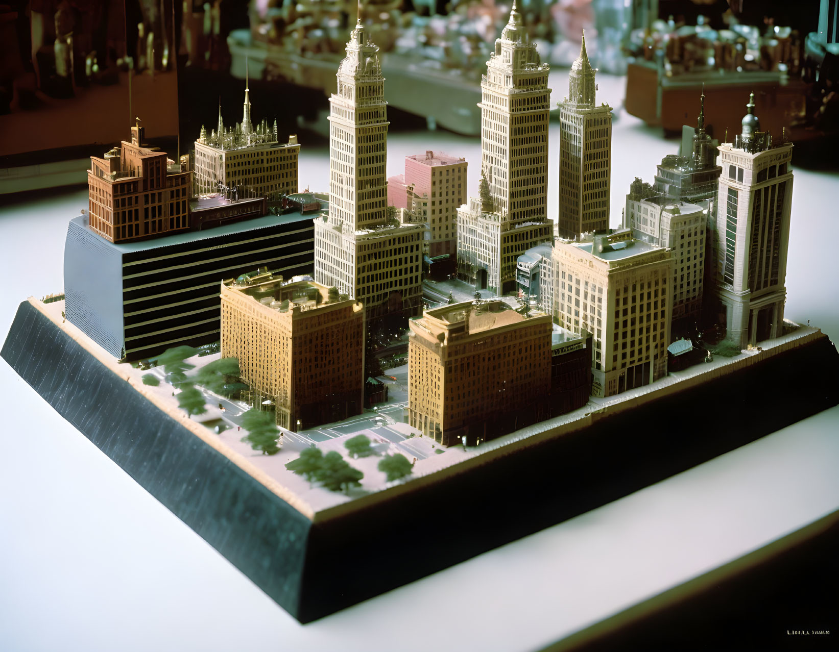 Detailed miniature cityscape model with high-rise buildings on platform.