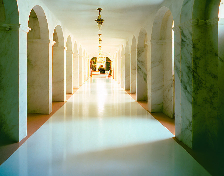 Sunlit White Marble Hallway with Arches and Distant Doorway