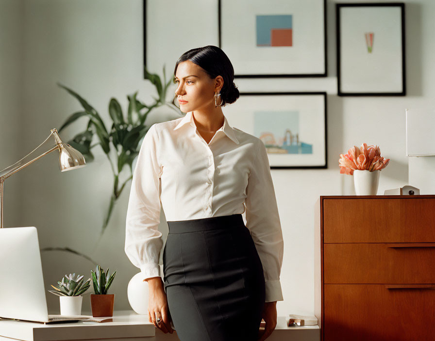 Professional woman in white shirt and black skirt at well-lit office desk