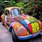 Colorful Patchwork-Patterned Volkswagen Beetle in Lush Garden