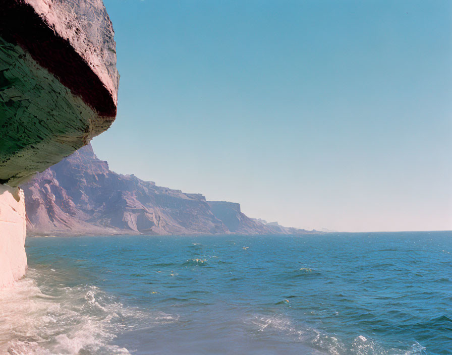 Rocky Cliff Extending into Serene Blue Sea