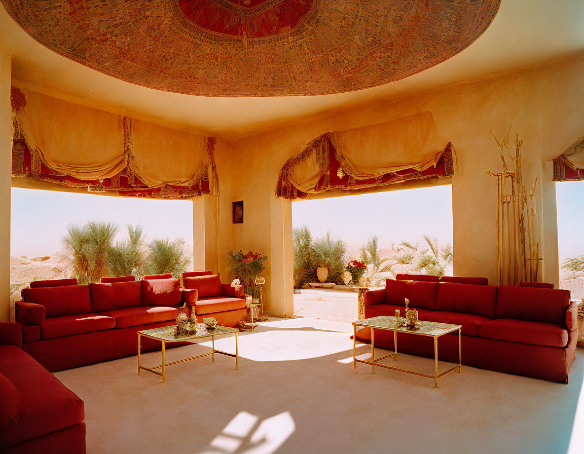 Desert-themed living room with red sofas, golden tables, and dome ceiling.