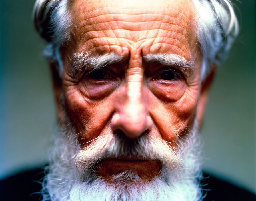 Elderly man with wrinkled face, intense eyes, and white beard