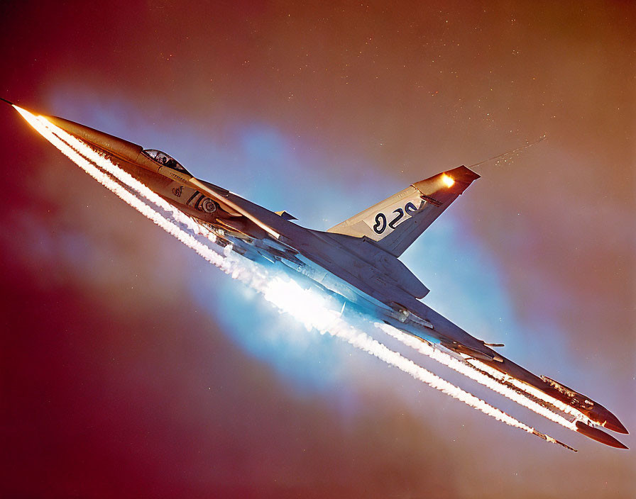 Military fighter jet with afterburners flying at dusk