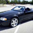 Black Convertible Sports Car with Chrome Rims Parked in Empty Lot