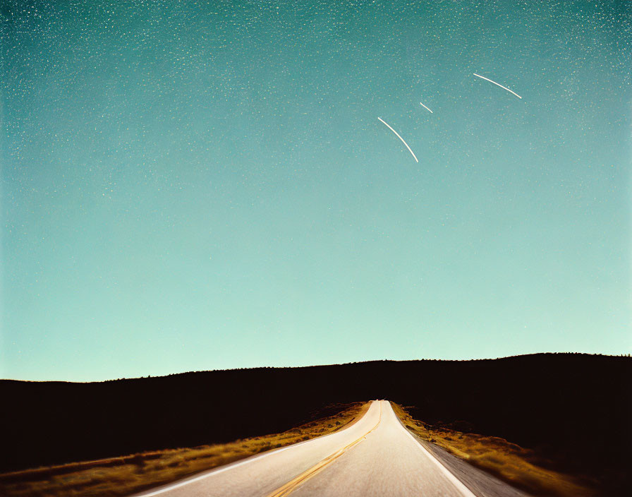 Dark night sky with stars above deserted road and shooting stars.