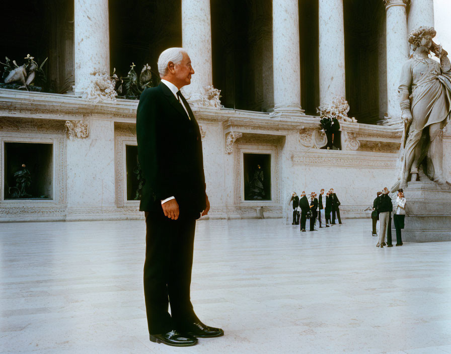 Distinguished man in grand hall with classical art and spectators