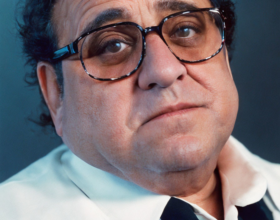 Man with Round Glasses and Curly Hair in White Shirt and Black Jacket