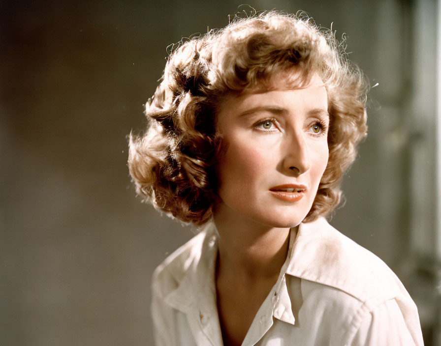 Vintage portrait of woman with curly hair in white blouse, thoughtful gaze