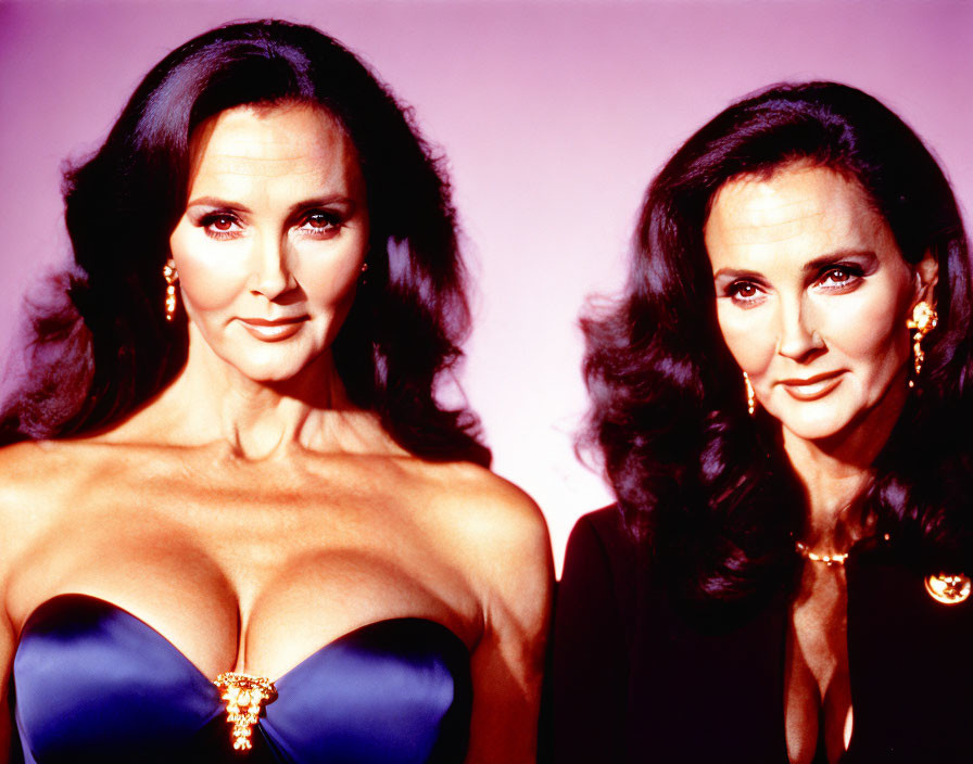 Two women in blue and black evening gowns with dark hair posing together.