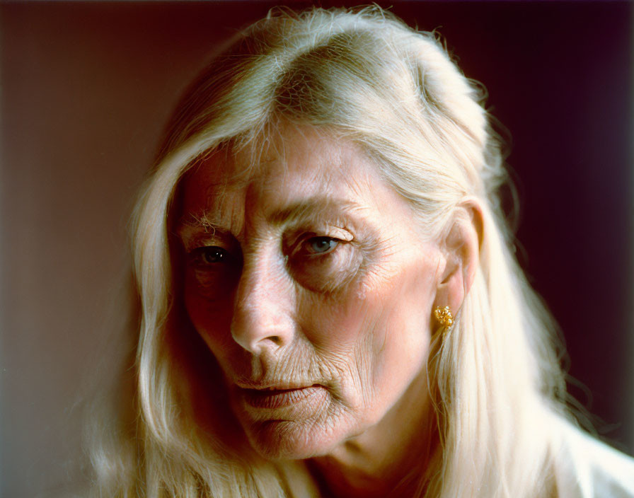 Elderly woman portrait with long blonde hair and piercing eyes