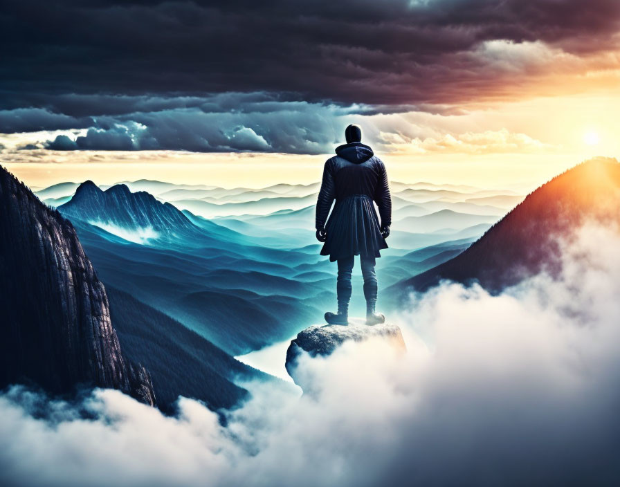 Person standing on cliff edge overlooking misty blue mountain ridges at sunrise