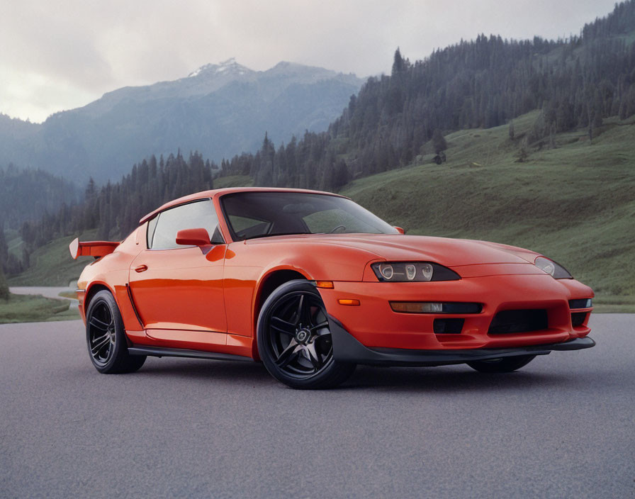 Orange Sports Car with Rear Spoiler in Scenic Mountain Setting