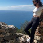 Stylish animated girl on floral cliff by the sea wearing sunglasses