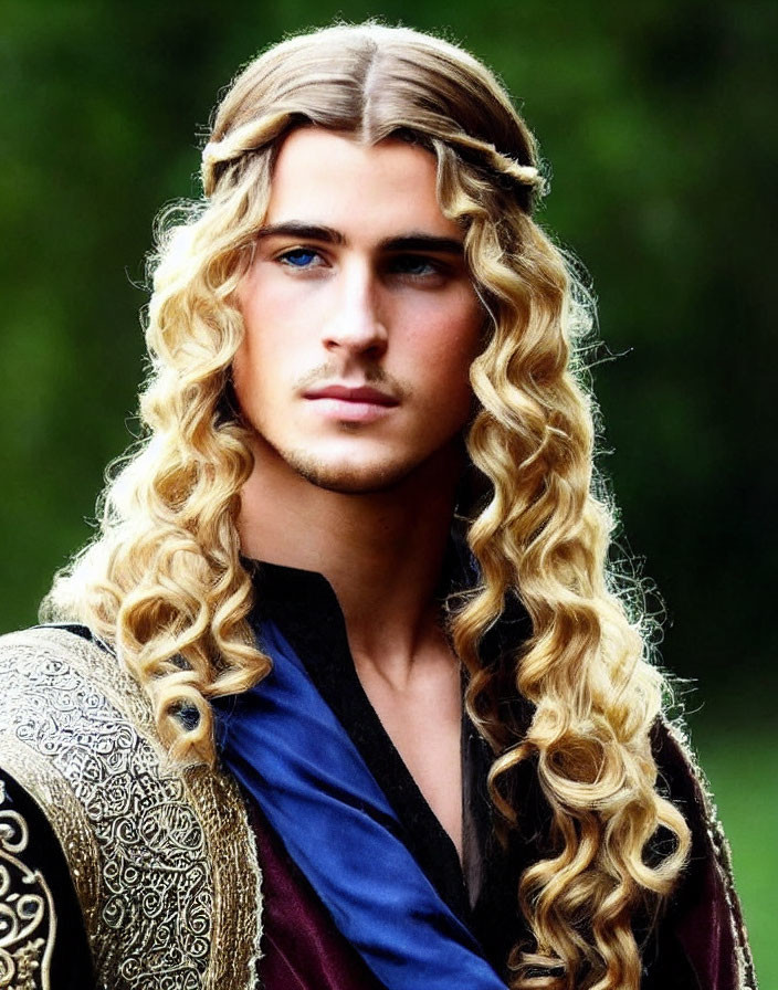 Young man with long blond hair in medieval attire with golden shoulder armor.