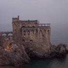 Majestic fairytale castle on coastal cliff with towers and lighthouse