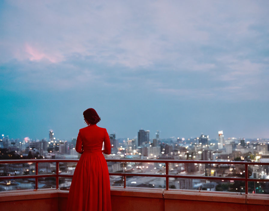 Woman in Red Dress on Rooftop at Dusk with Cityscape View