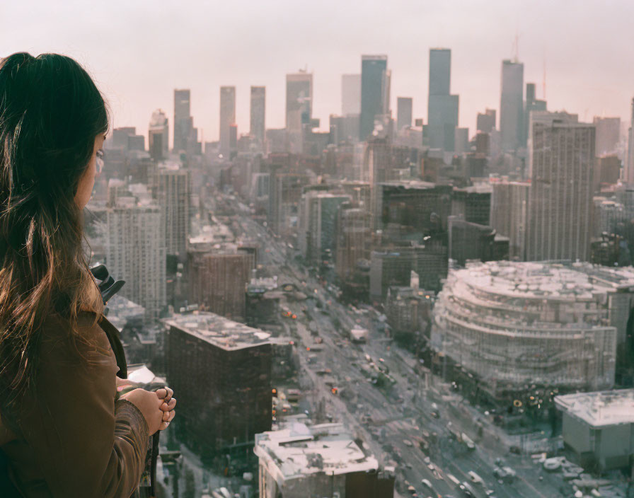 Woman observing city skyline with hazy skyscrapers