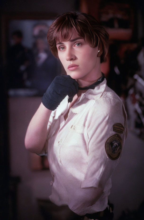 Contemplative woman in retro police uniform with badge and gloves