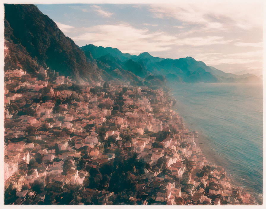 Sepia-Toned Coastal Town with Mountain Range and Cascading Buildings