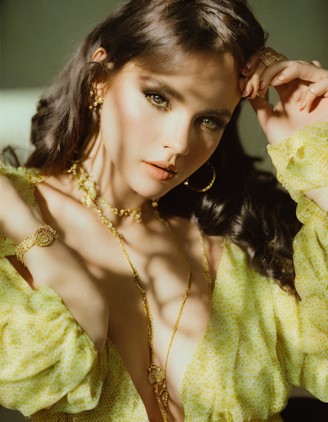 Woman with Striking Makeup and Curly Hair in Yellow Patterned Outfit and Gold Jewelry