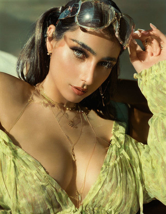 Woman in Bold Makeup and Sunglasses Poses in Green Ruffled Outfit