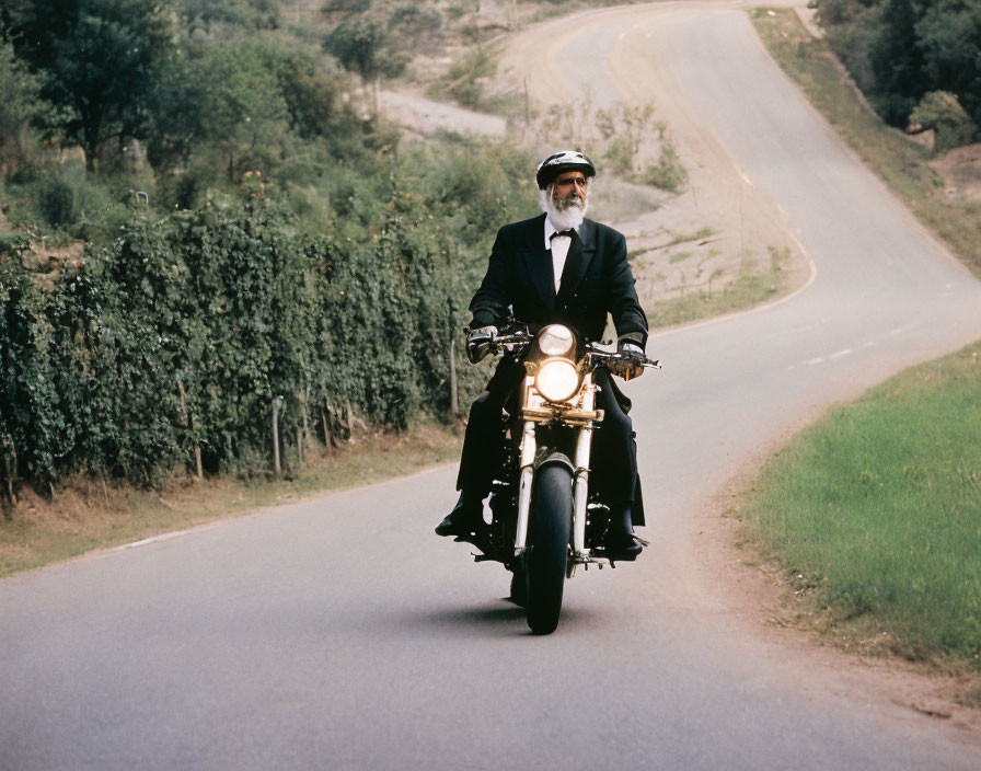 Bearded man on motorcycle rides country road with greenery