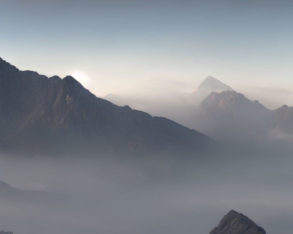 Sunlit misty mountain ranges under soft clouds