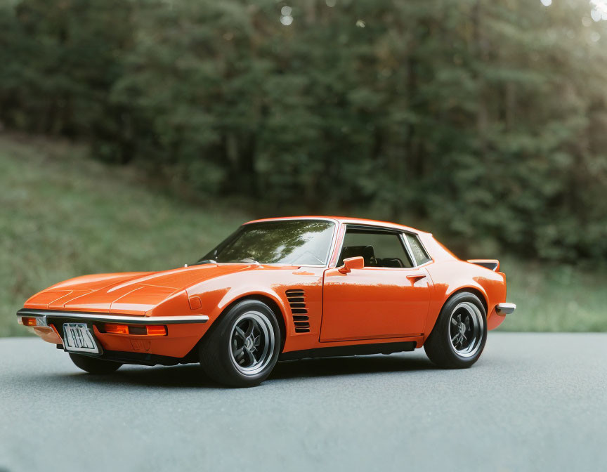 Vintage Orange Toy Car Model on Flat Surface with Blurred Nature Background