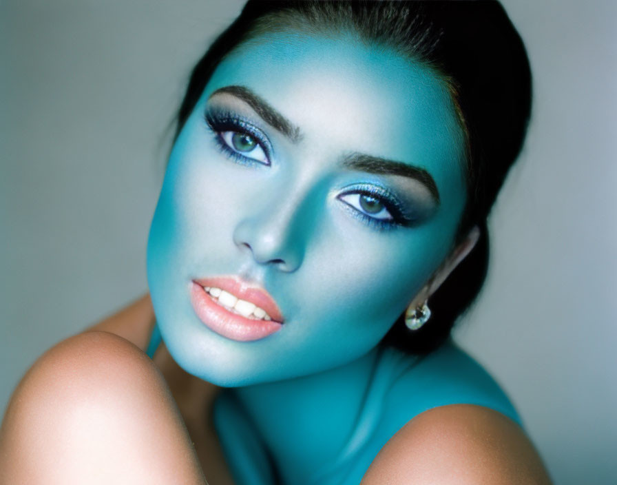 Portrait of woman with striking blue makeup and captivating eyes on dark background