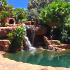 Colorful Fantasy Landscape with Red Rock Formations, Waterfalls, and Serene Pond