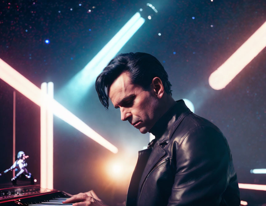 Man in leather jacket plays keyboard with neon lights in space-themed setting