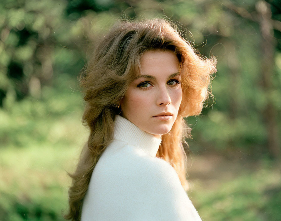 Blonde woman in white turtleneck sweater gazes over shoulder in greenery