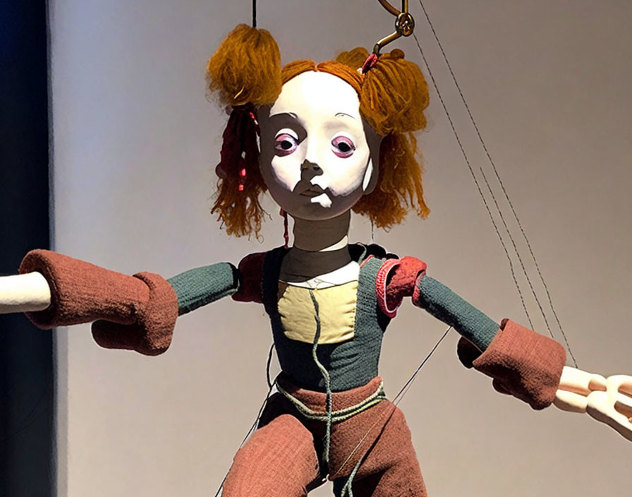 Orange-haired marionette puppet in green and brown outfit