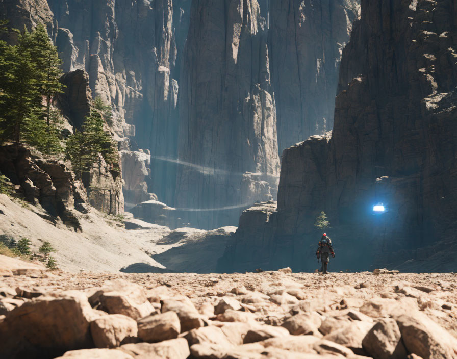 Person walking in rocky terrain with towering cliffs and sunlight beams