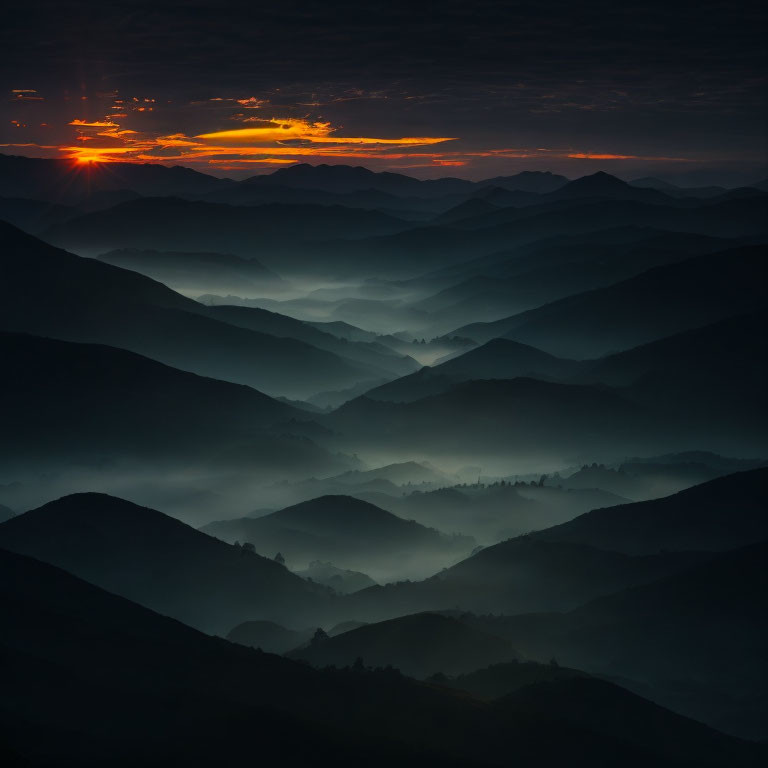 Sunset over Misty Mountains: Silhouetted Hills and Orange Sky